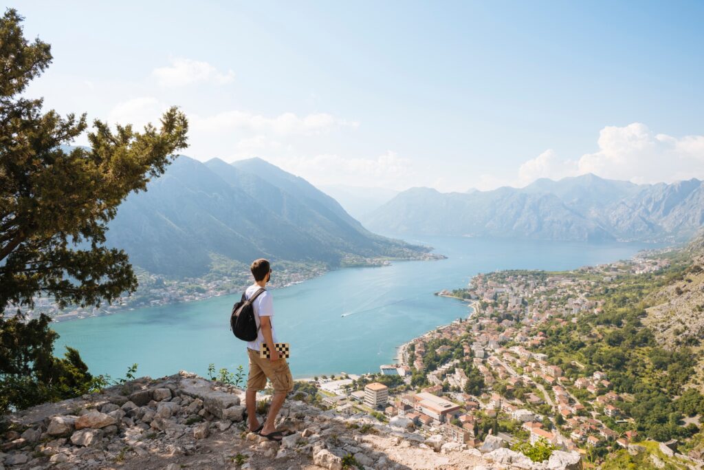 Hiker on mountain looking away at elevated view of sea, Kotor, Montenegro, Europe