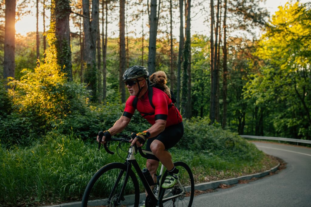 Senior man cycling with his puppy