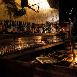 A cozy bar setup with whiskey bottles and warm candlelight, creating a relaxed mood.