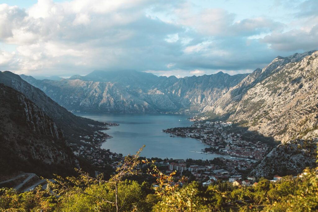 Breathtaking aerial view of the Bay of Kotor surrounded by dramatic mountains under a cloudy sky.