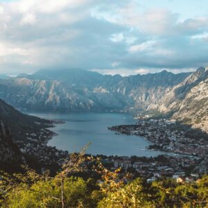 Breathtaking aerial view of the Bay of Kotor surrounded by dramatic mountains under a cloudy sky.